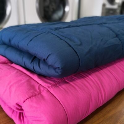 Folded clean Comforters on folding table in laundry