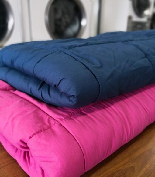 Folded clean Comforters on folding table in laundry